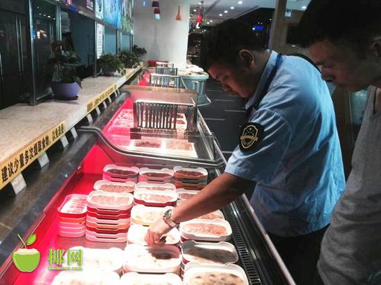 海口市龙华区食药监管局执法人员正在检查肉卷