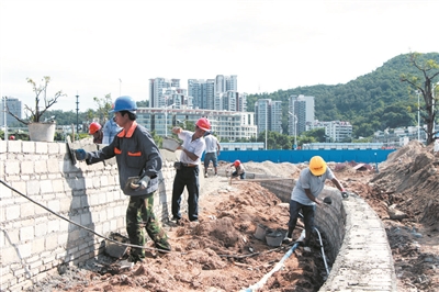 工人正在加紧施工以确保项目如期完工。本报记者汪慧珊摄