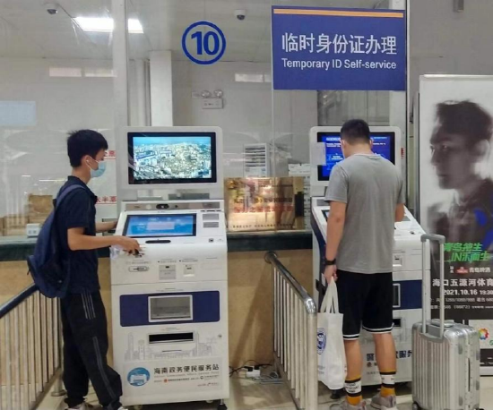 （图：群众在海口市汽车西站便民服务站自助机上办理业务）
