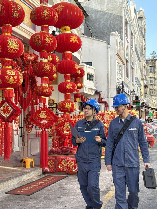 海口供电局工作人员对商铺开展用电检查，保障商户经营用电。（杨永光 林国凯）