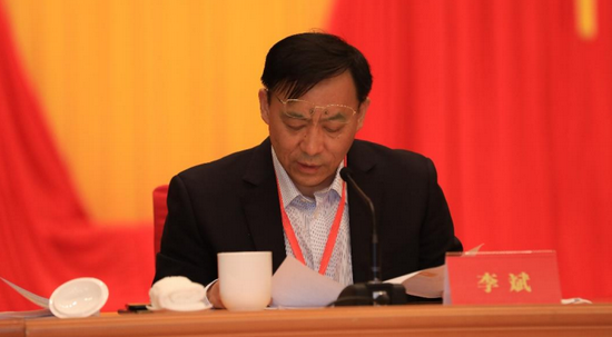常务副会长中国邮政储畜银行海南省分行行长李斌宣读《海南省商业总会章程》（修正案）。