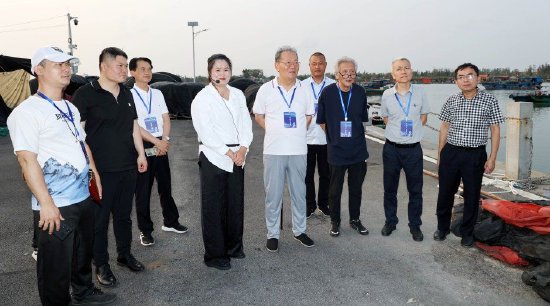 李公羽（中）与省内外专家组成的考察组在儋州市光村镇泊潮港考察调研