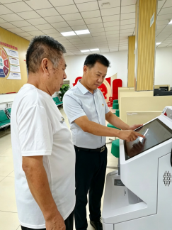 图：营销员党员张小刚为客户办理保单查询业务