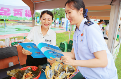 （图为在2024年屯昌县第二届端午旅游美食文化节系列活动启动仪式上，税务干部向粽子展商宣讲增值税小规模纳税人相关政策。张宁摄）