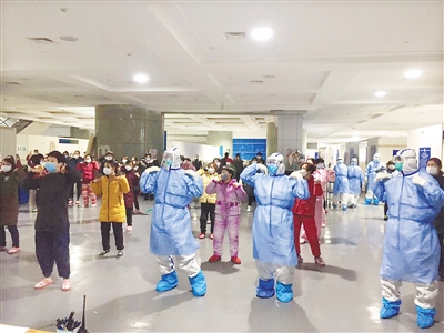 国家紧急医学救援队(海南)队员与方舱医院的患者一起跳广场舞。