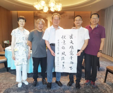 　　李公羽向杭州市苏东坡研究专委会赠送书法作品：苏东坡在海南儋州所作诗句“垂天雌霓云端下，快意雄风海上来”