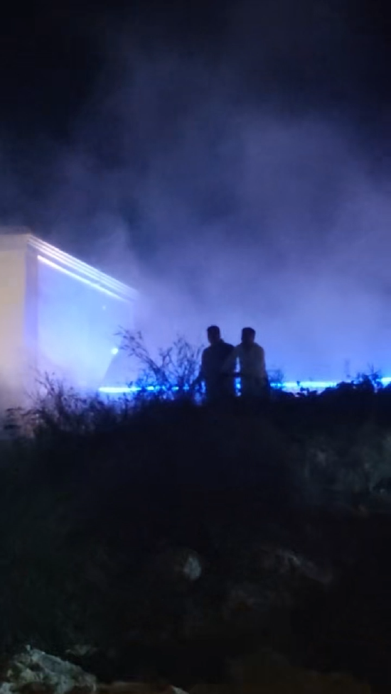 消防员刘金玉（右）与热心群众一起灭火。网友视频截图