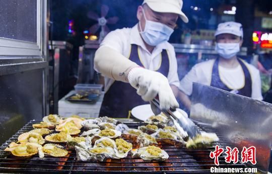 夜市摊主在制作烤生蚝。　吴天军 摄