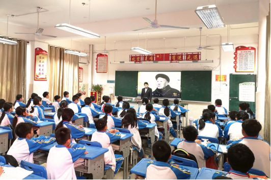  图为建行青年志愿者为学生讲述老英雄张富清的感人事迹。