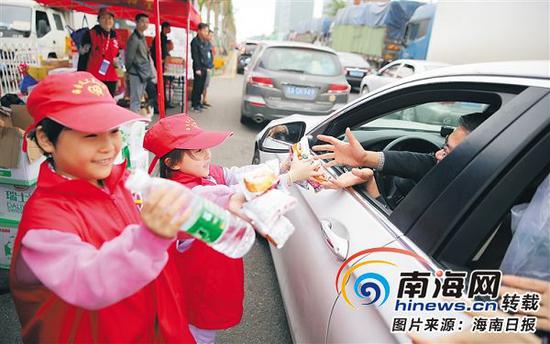 志愿服务志愿服务成为海口城市文明的名片。图为海口市新海港附近，小志愿者给滞留车辆送水。本报记者张茂摄