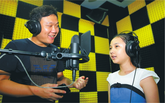 　　蔡科文（左）在澄迈县水滴音乐创作基地录音棚指导何瑞莹录歌曲。 本报记者 苏晓杰 通讯员 王家专 摄