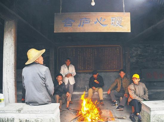 每年寒冬，海口市石山镇美社村的老人都会聚集在“暖心庐舍”里烤火取暖。 张王明 摄