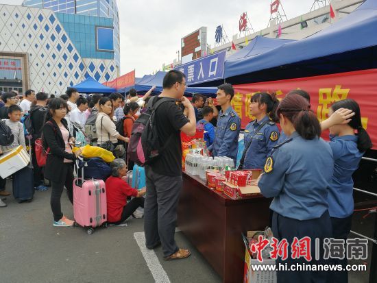 图为交通系统志愿者为旅客服务。