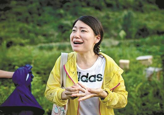 图为:“好疼!”在蜂场学艺时,王庆年的左手一不留神被蜜蜂蜇了,痛得她直流泪
