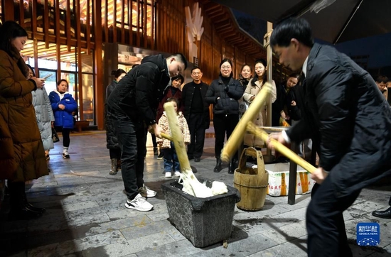 　　2月9日，游客在宣恩县兴隆老街体验打糍粑。 新华社发（宋文摄）