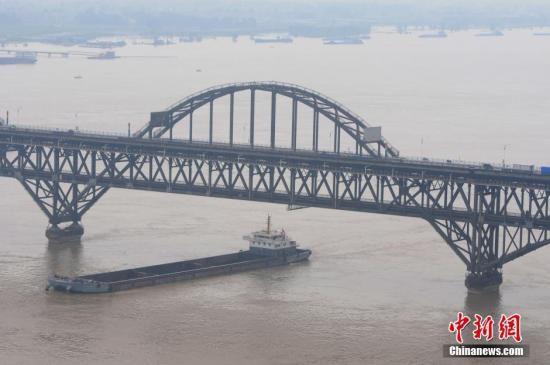 图为7月5日，船只驶过超警戒线水位的长江江西九江段。 胡国林 摄