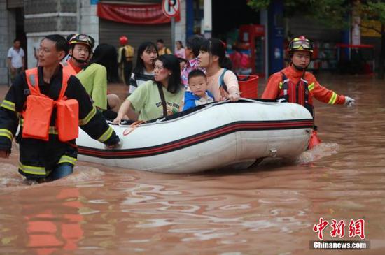 6月28日，重庆涪陵区龙潭镇龙潭河河水急剧上涨，龙潭河沿线及场镇大面积被淹，多处道路被冲毁、房屋被浸泡。重庆涪陵区委、区政府积极组织区人民武装部、区应急管理局、区消防救援支队等部门开展人员疏散及防汛抢险工作。图为消防救援人员紧急转移被困民众。 肖乐峰 摄