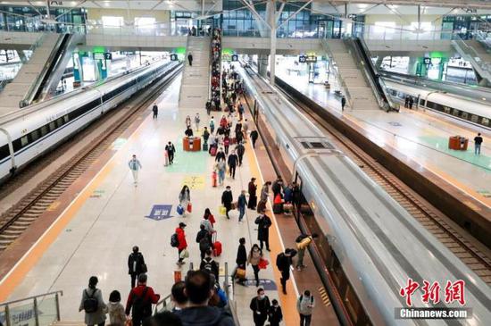 资料图：旅客在武汉火车站站台准备乘坐高铁列车。