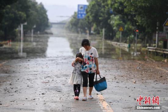 连日来，衡东县出现了持续强降雨天气，造成该县17个乡镇、233个村、22个社区普遍受灾。图为两位村民在东健大道上折返回家。（资料图片）杨华峰 摄