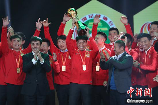 中超冠军广州恒大淘宝队队长郑智捧起火神杯。张亨伟 摄
