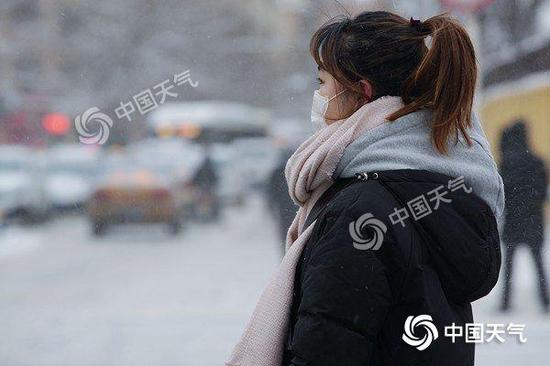 昨天，哈尔滨雪花纷飞降温明显，行人捂得很严实。（图/吕国君）