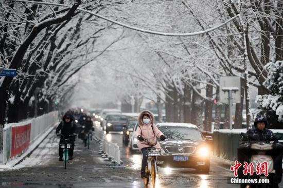 资料图：1月6日，北京降雪，市民雪后出行。 中新社记者 盛佳鹏 摄