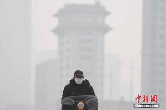 资料图：山西省太原市持续雾霾天气，市民戴口罩出行。中新社记者 武俊杰 摄