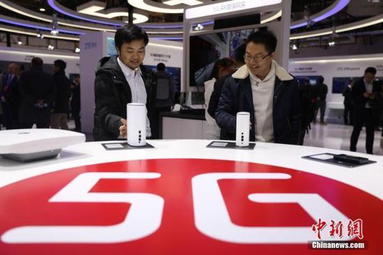 资料图:参观者在近距离观看5G室内路由器。中新社记者 蒋启明 摄
