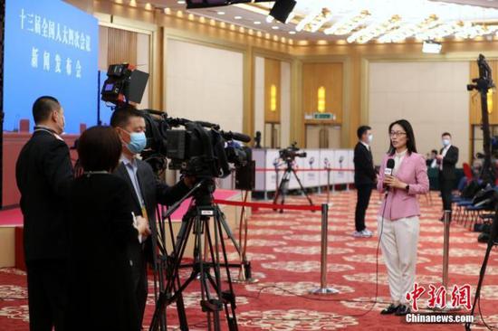 3月4日晚，十三届全国人大四次会议新闻发布会在北京人民大会堂新闻发布厅举行。图为新闻发布会开始前，央视记者在分会场梅地亚中心内进行直播。 中新社记者 蒋启明 摄