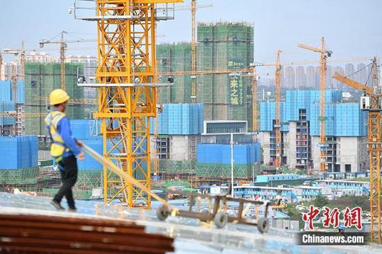 资料图:一在建楼盘工地工人正在忙碌。 中新社记者 张浪 摄