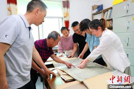 马良云(左二)分享收藏的书刊 陈黄奎 摄