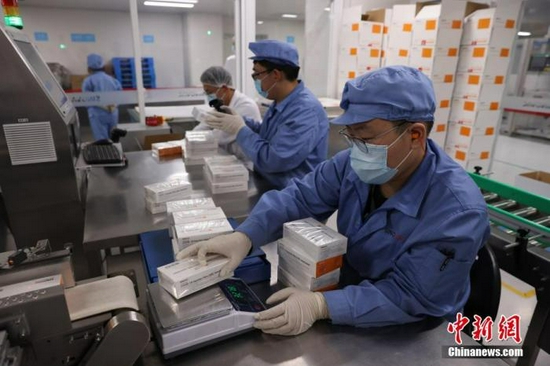 资料图：工作人员在对疫苗进行包装称重。 中新社记者 蒋启明 摄