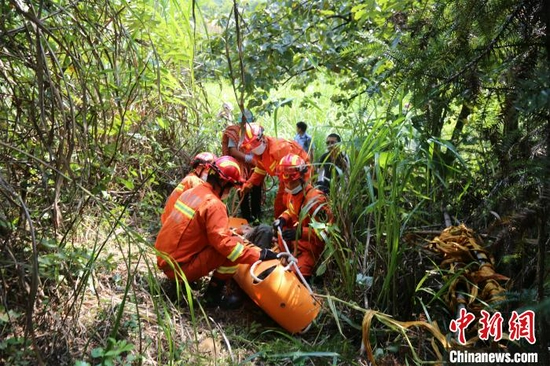  救援人员将受伤驴友固定在担架上 黄波萍 摄