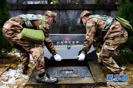 图为1月26日，在湖北省咸丰县烈士陵园，民兵将烈士棺椁安葬进烈士墓内。新华网发 李维君摄