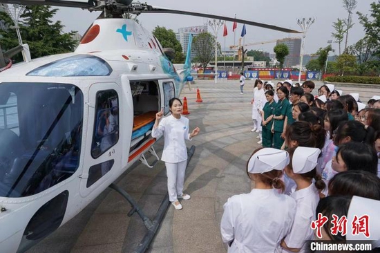 图为湖北医药学院老师正在为学生讲解直升机内的救援设备 刘成臣 摄