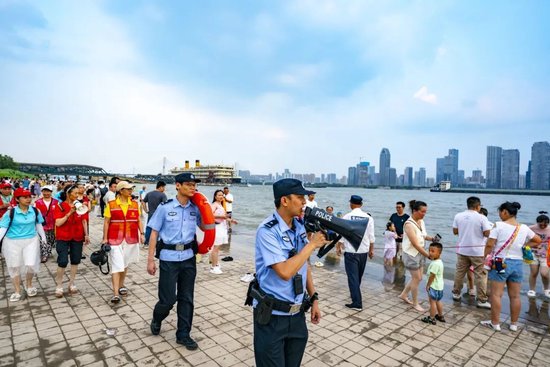 ▲水上分局民警和长江义警在汉口江滩开展防溺水宣传
