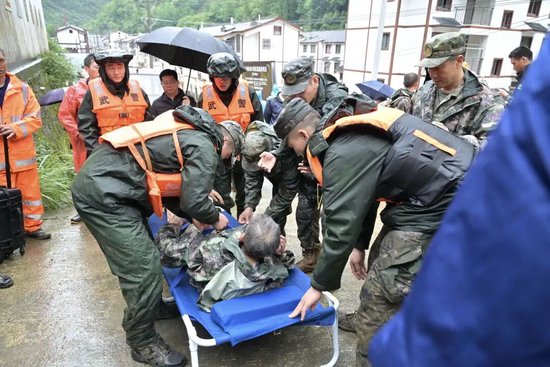 武警、民兵用担架将高龄老人护送下山。 （湖北日报通讯员 陈绪开 摄）