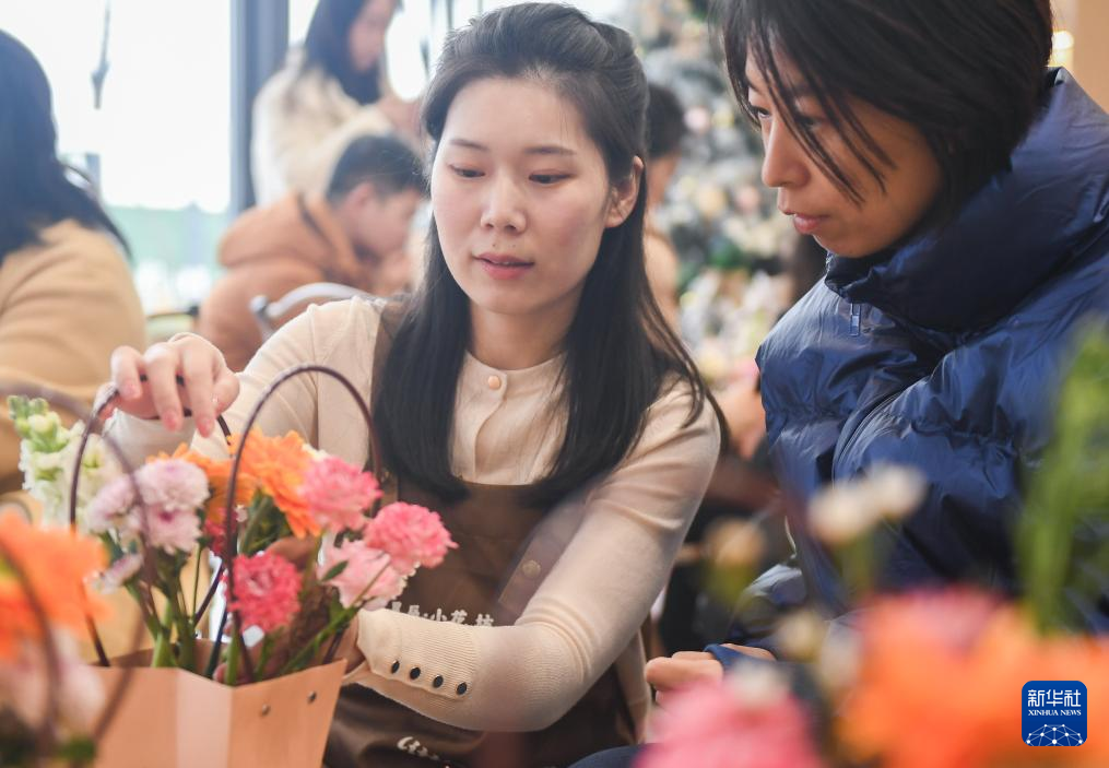 1月14日，在武汉市东湖高新区联投新青年·花山河社区共享客厅，教师黄莎莎（左）指导学员插花。新华社记者 杜子璇 摄