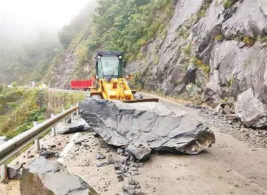 图为：鹤峰清理道路上的山石
