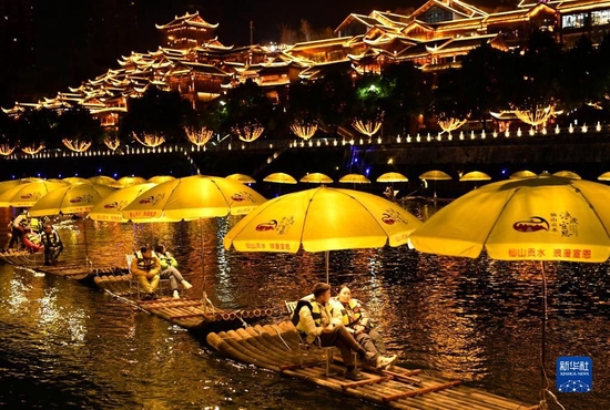 　　2月9日，游客乘坐竹筏在宣恩县兴隆老街前的贡水河上游玩。 新华社发（宋文摄）