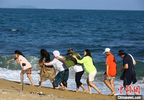 5月3日,游客在三亚南山文化旅游区海边游玩。 陈文武 摄