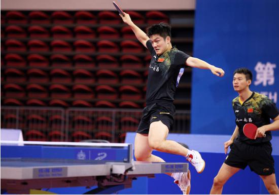 中国选手樊振东（左）、周雨在比赛中。