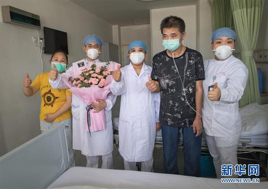 6月17日，胡定江与妻子为医护人员送上献花后合影。新华社记者 肖艺九 摄