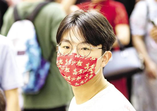 6月7日,武汉市第二中学考点,一名考生戴着“高考必胜”字样的口罩走进考场。 (湖北日报全媒记者 柯皓 摄)