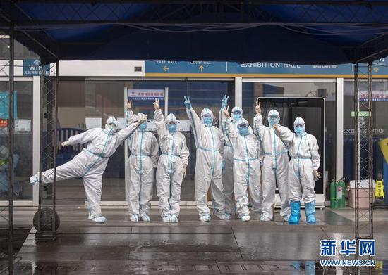 3月9日，最后一批结束工作后从江汉方舱医院走出的河南医疗队队员在出舱后合影。  新华社记者 费茂华 摄