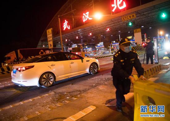 4月8日凌晨，在武汉北高速收费站，工作人员移除围栏。 新华社记者 肖艺九 摄