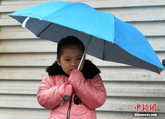 资料图：女孩穿着厚实冬装抵御寒冷。中新社记者 翟羽佳 摄