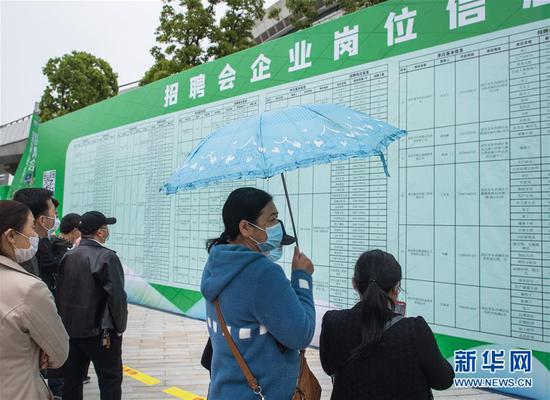 4月21日，求职者在武汉市复工复产企业用工现场招聘会上查看招聘信息。 新华社记者 肖艺九 摄