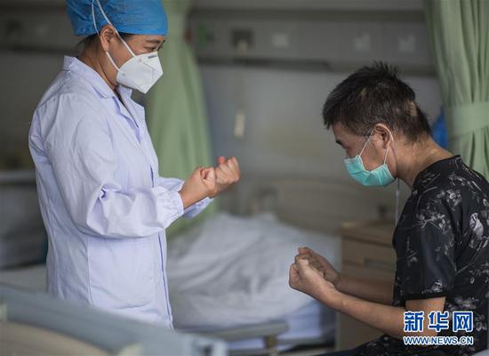6月17日，医生朱琦在病房指导胡定江进行恢复训练。新华社记者 肖艺九 摄