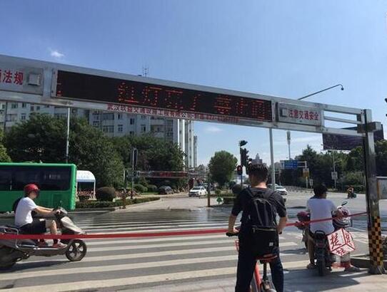 武汉街头,自动拉绳系统,“红灯亮了,禁止通行,在等候区等待。”